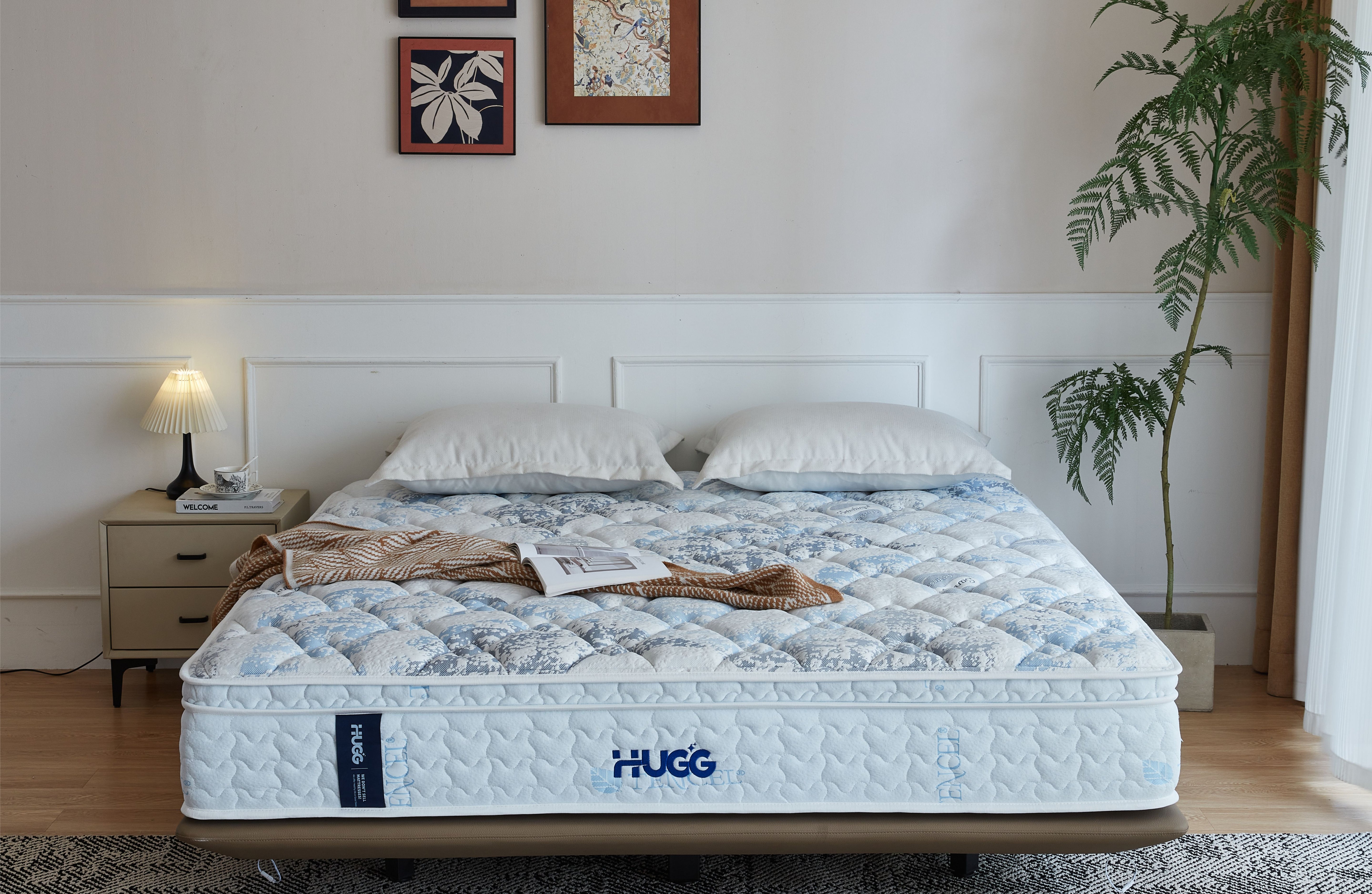 Hugg mattress in a bedroom setting with a nightstand and plant.