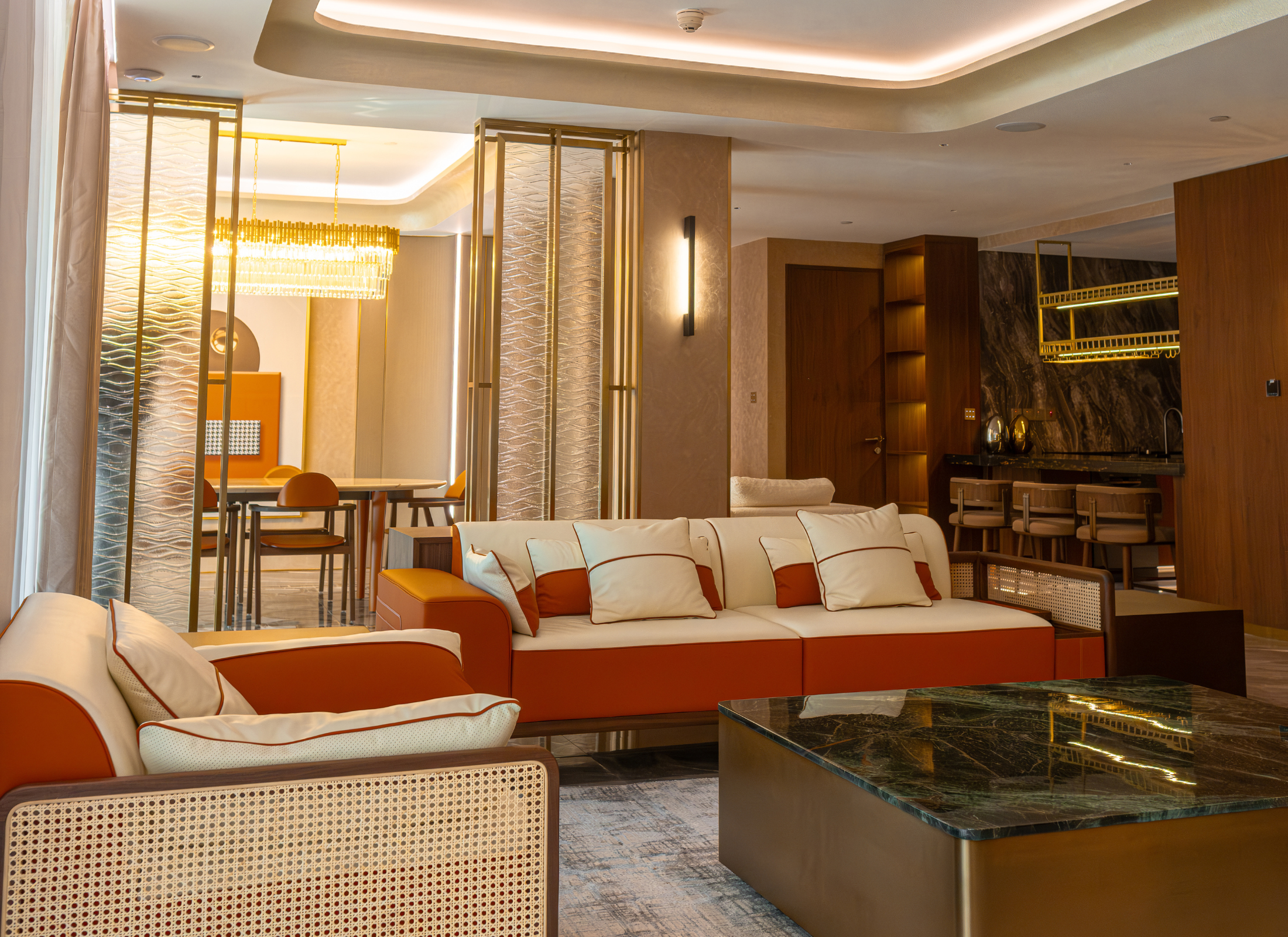 Luxurious living room with orange and beige sofa, glass coffee table, and decorative elements.
