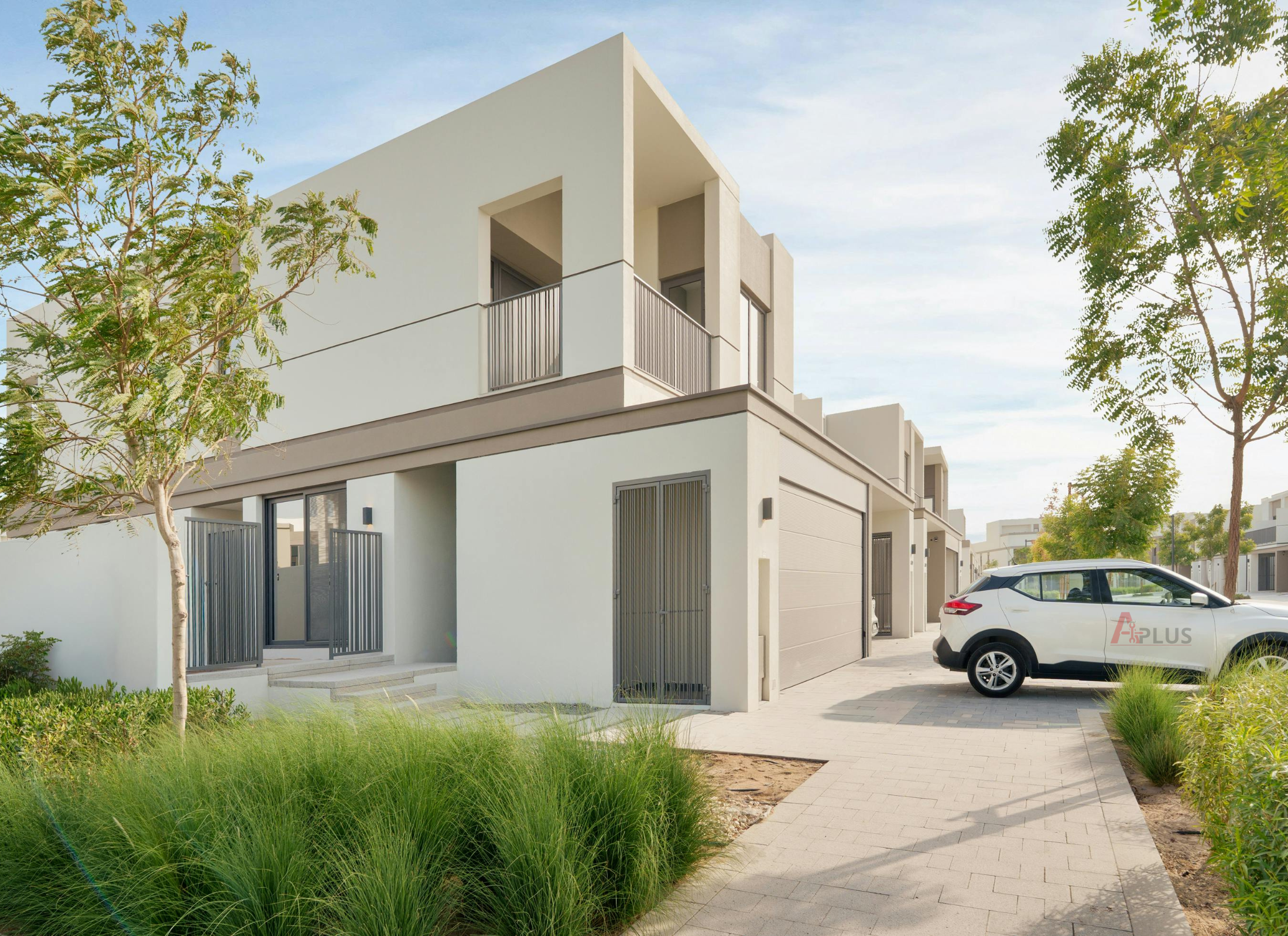 Modern house with a white car parked outside on a clear day