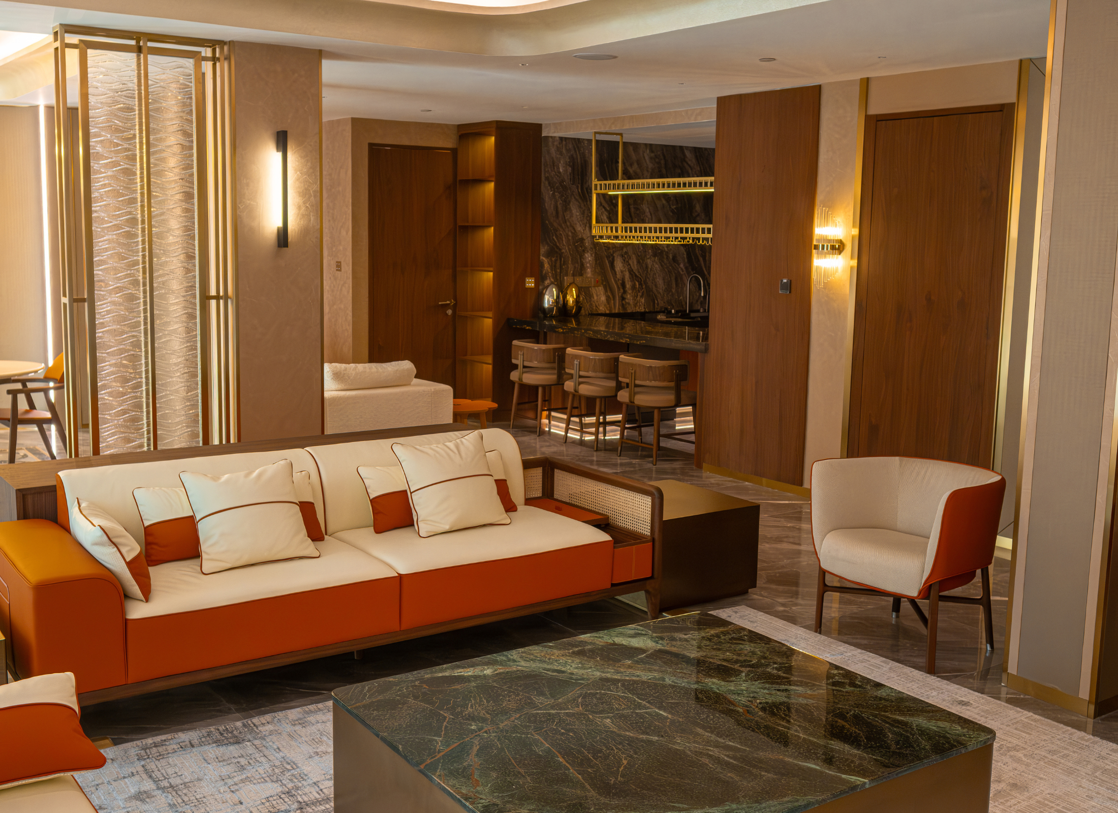 Modern living room with orange sofa, white chairs, and a glass coffee table.